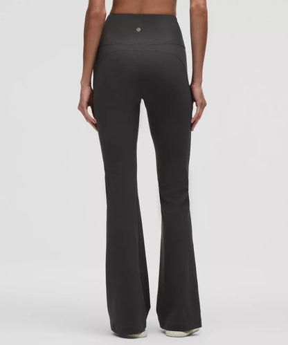 Black flared pants worn by a person on a white background