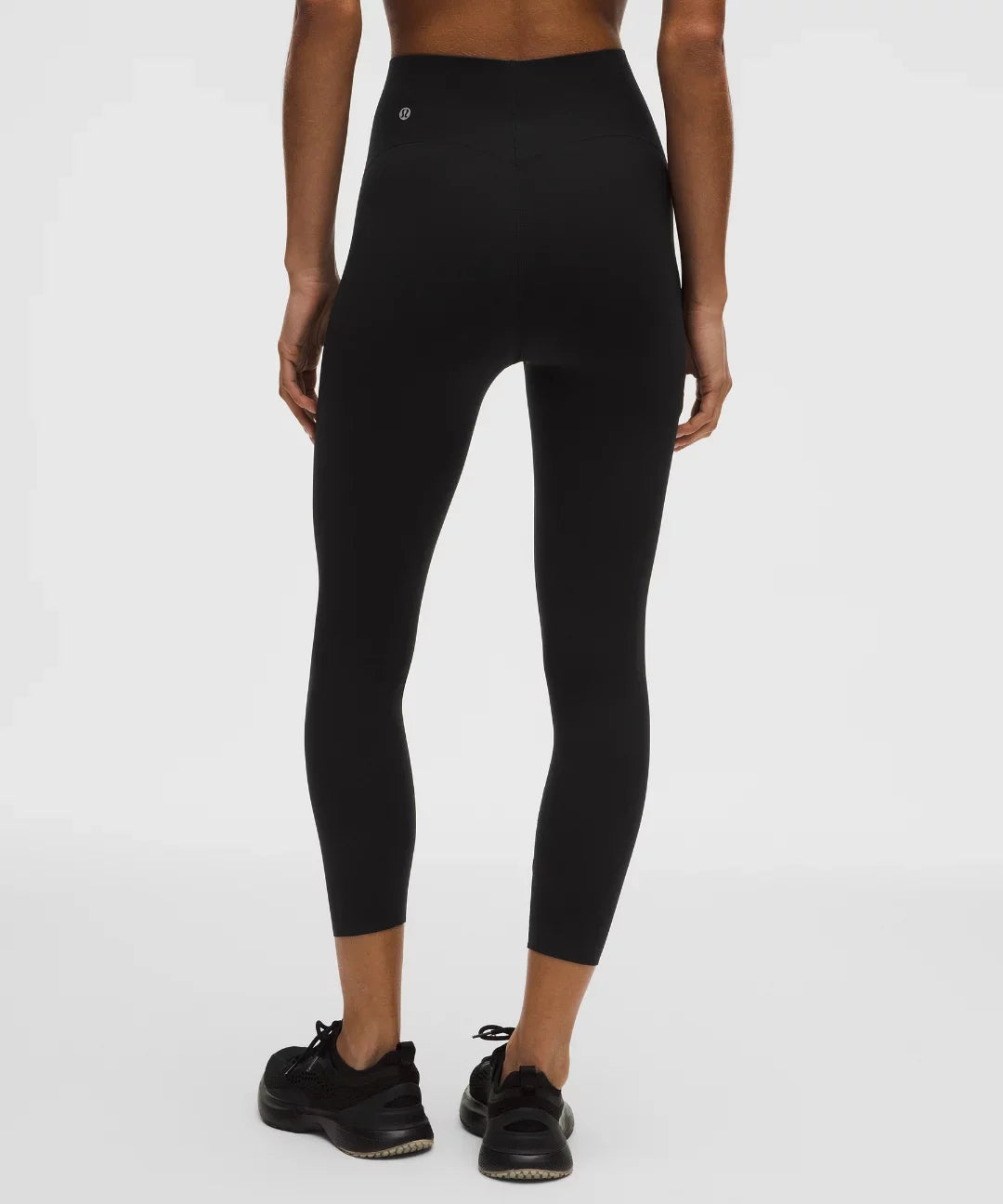 Person wearing black leggings on a white background