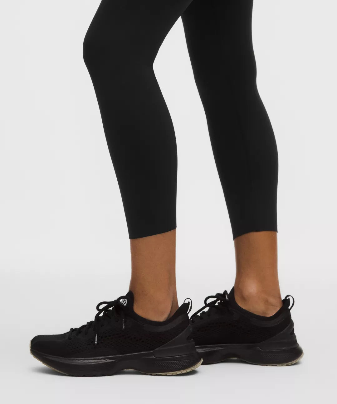 Black athletic shoes and leggings on a white background