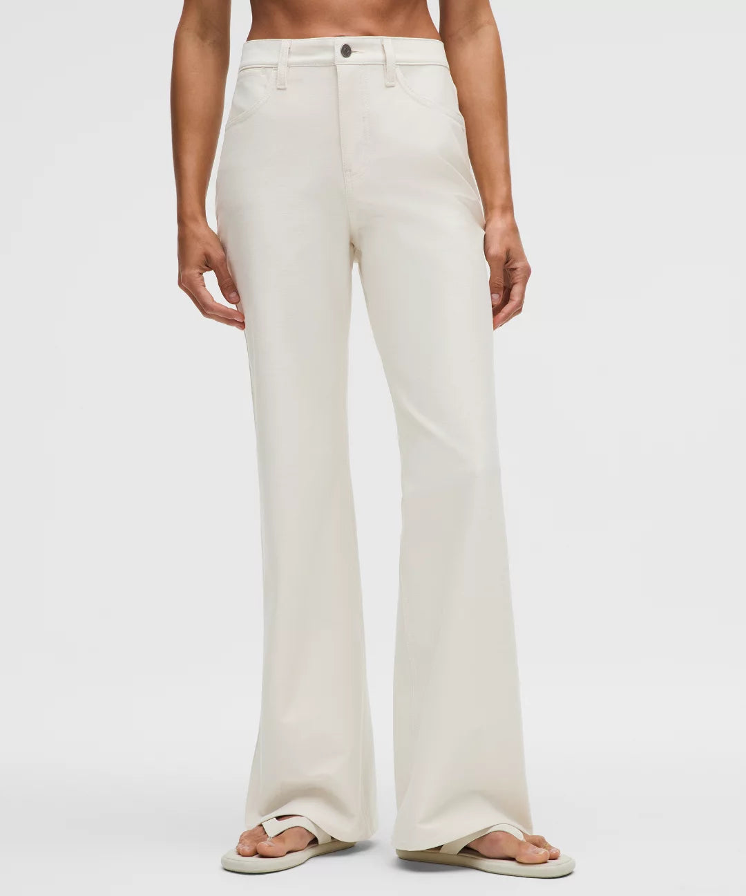 Person wearing white wide-leg pants on a plain background
