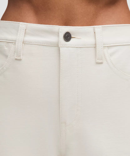 Close-up of beige pants with a button on a neutral background