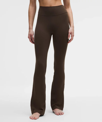 Brown yoga pants worn by a person on a white background