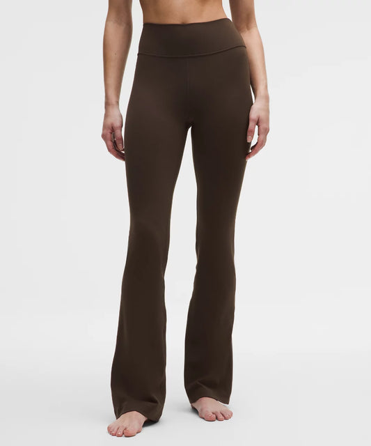 Brown yoga pants worn by a person on a white background