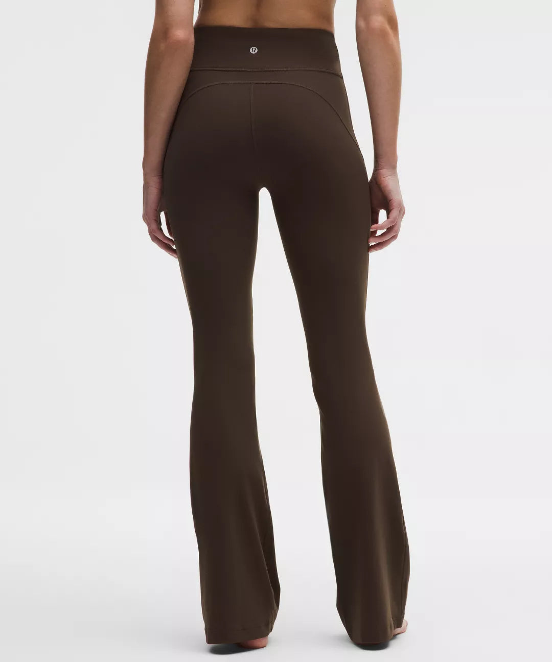 Brown flared pants worn by a person on a white background