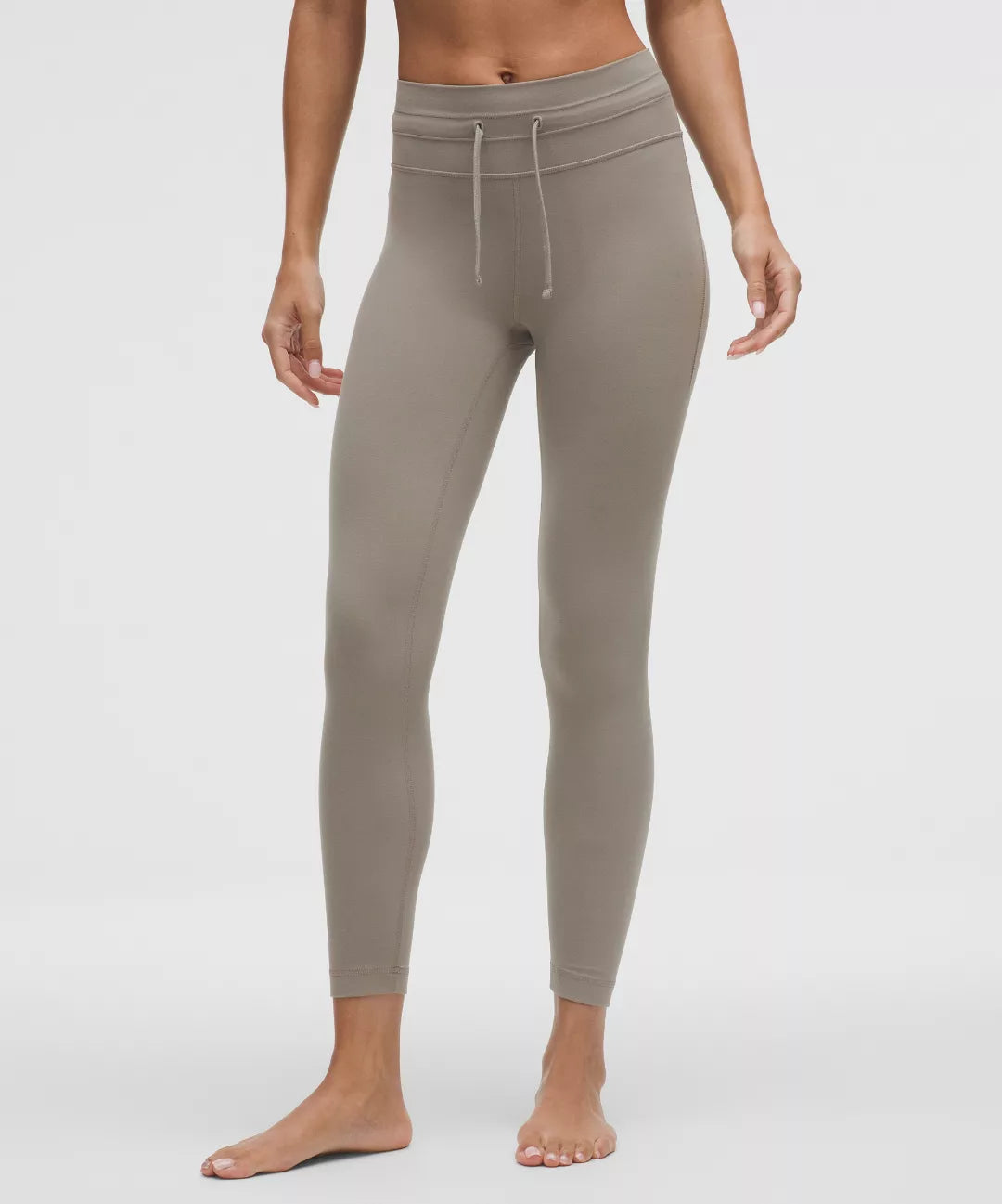 Beige leggings worn by a person on a white background