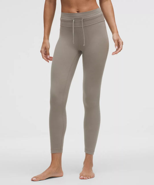 Beige leggings worn by a person on a white background