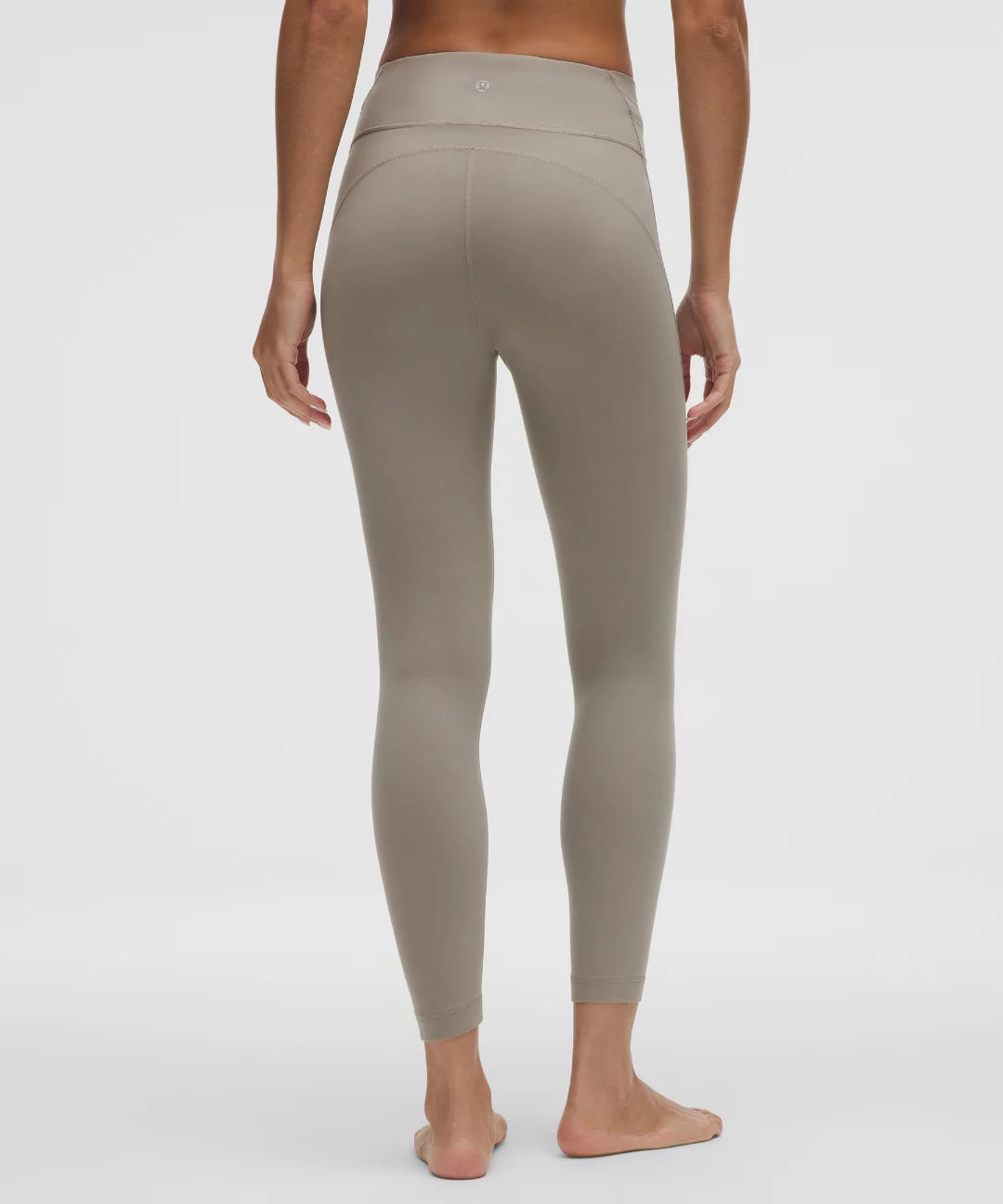 Person wearing beige leggings on a white background