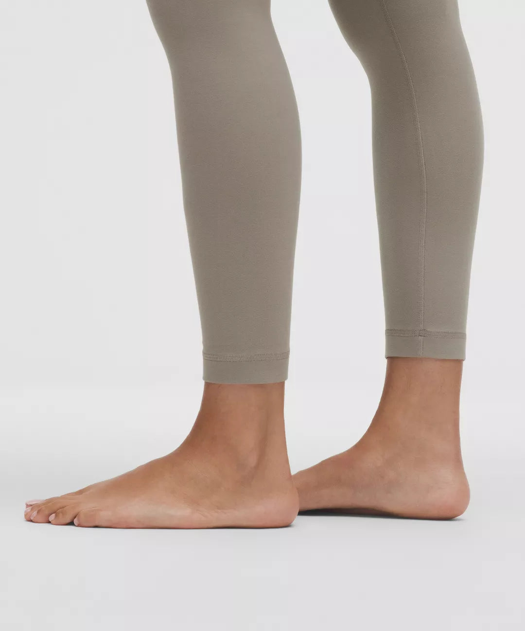 Beige leggings worn by a person on a white background