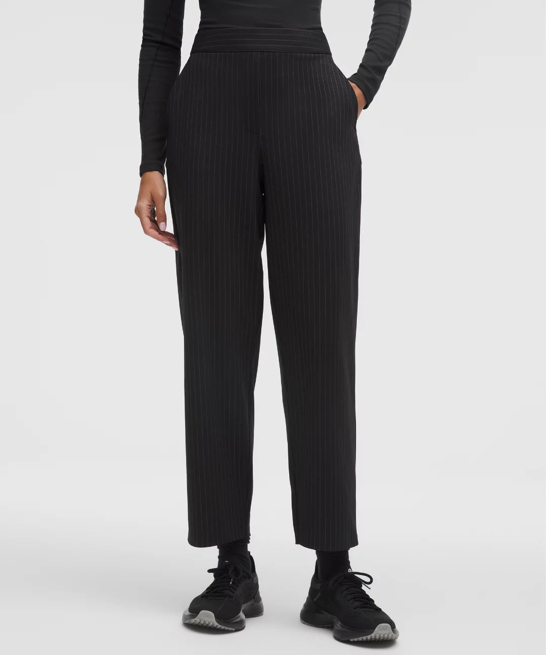 Person wearing black ribbed pants on a white background