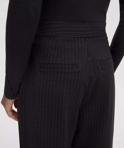 Black pinstripe pants worn by a person on a white background