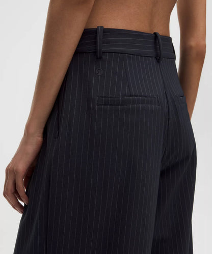Black pinstripe pants worn by a person on a white background