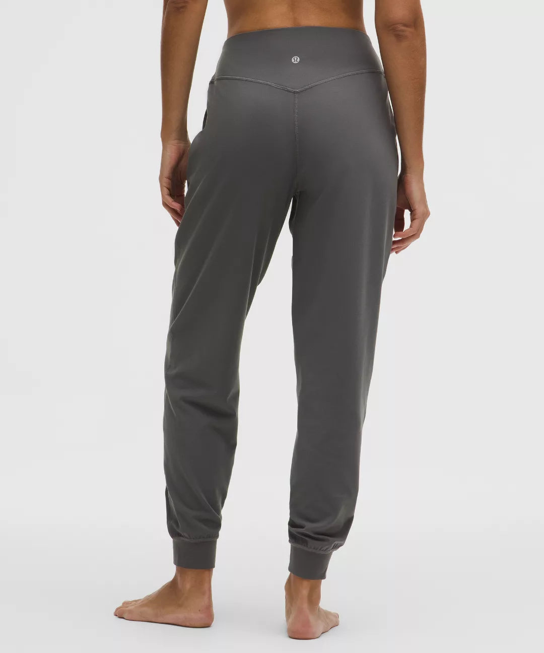 Gray jogger pants worn by a person on a white background