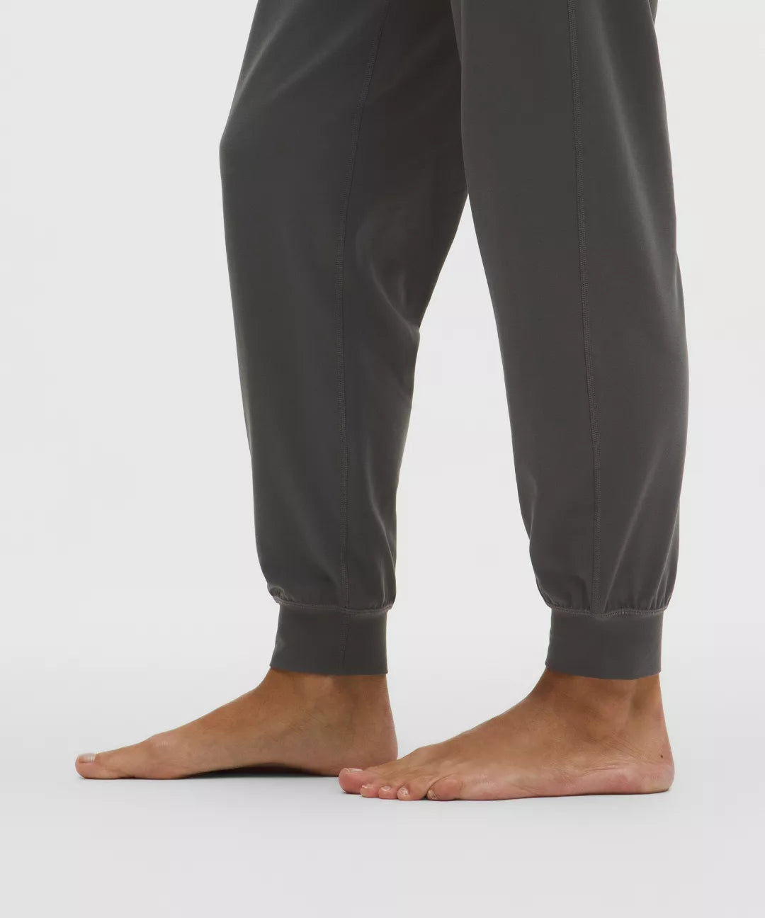 Gray sweatpants worn by a person on a white background
