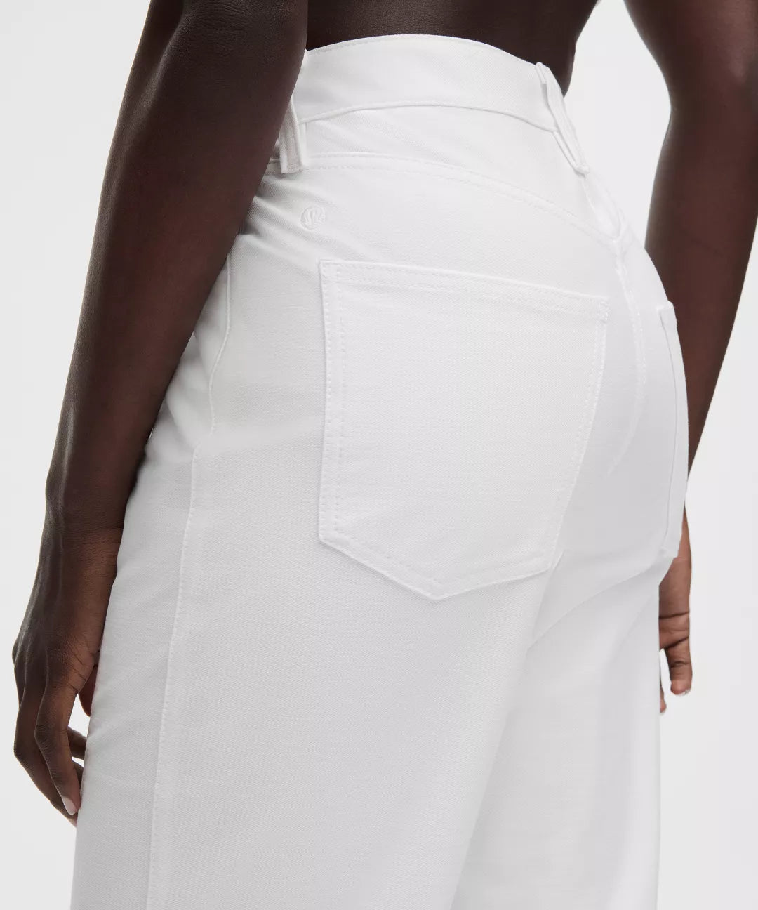White pants worn by a person on a white background
