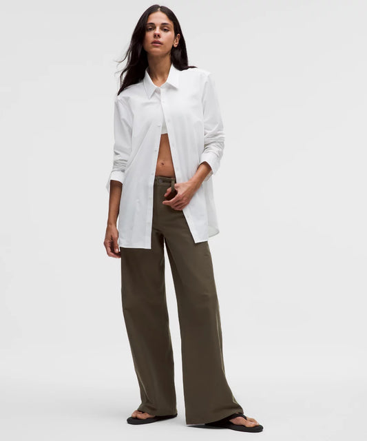 Woman wearing a white shirt and olive green pants on a white background