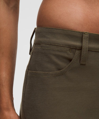 Close-up of olive green pants on a plain background