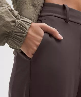 Person wearing brown pants with a neutral background