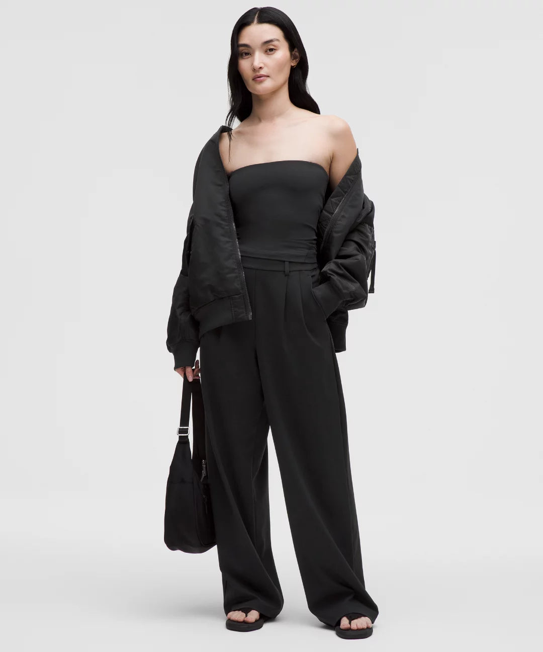 Woman wearing a black outfit with a jacket on a white background