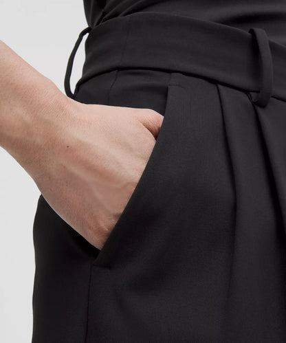 Person wearing a black outfit with a tie detail on a white background