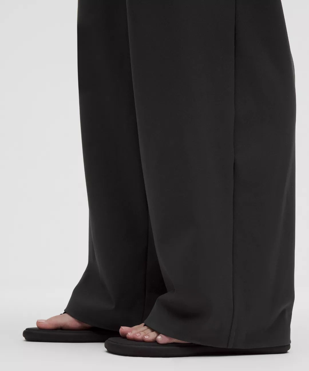 Black wide-leg pants worn by a person on a white background