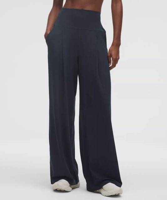 Navy blue wide-leg pants worn by a person on a white background