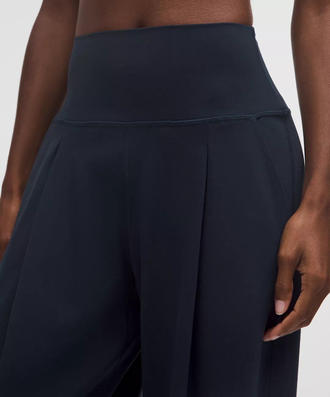 Black high-waisted pants worn by a person on a white background