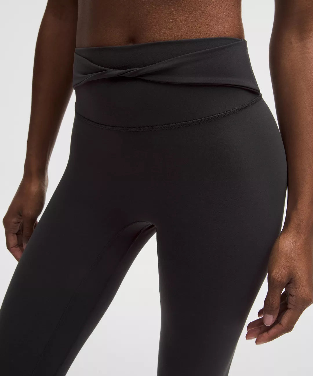 Black high-waisted leggings worn by a person on a white background