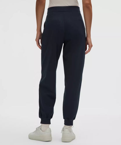 Navy blue jogger pants worn by a person on a white background