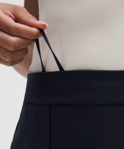 Person holding a black bag with a neutral background