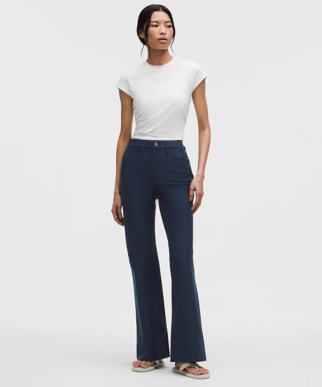 Woman wearing a white t-shirt and dark blue jeans on a white background