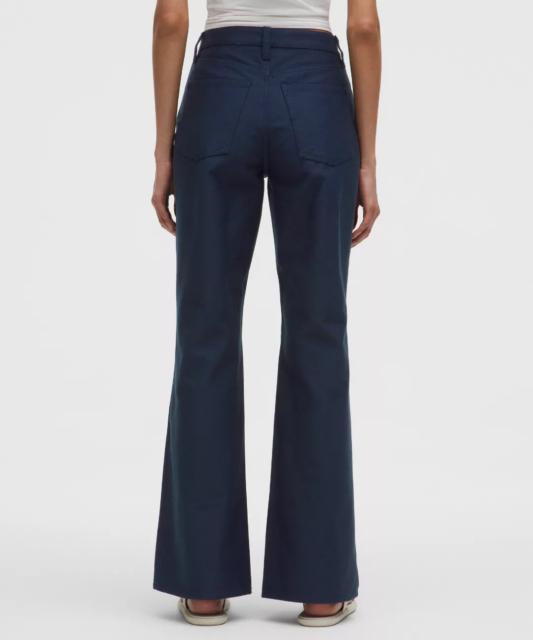 Navy blue flared pants worn by a person on a white background