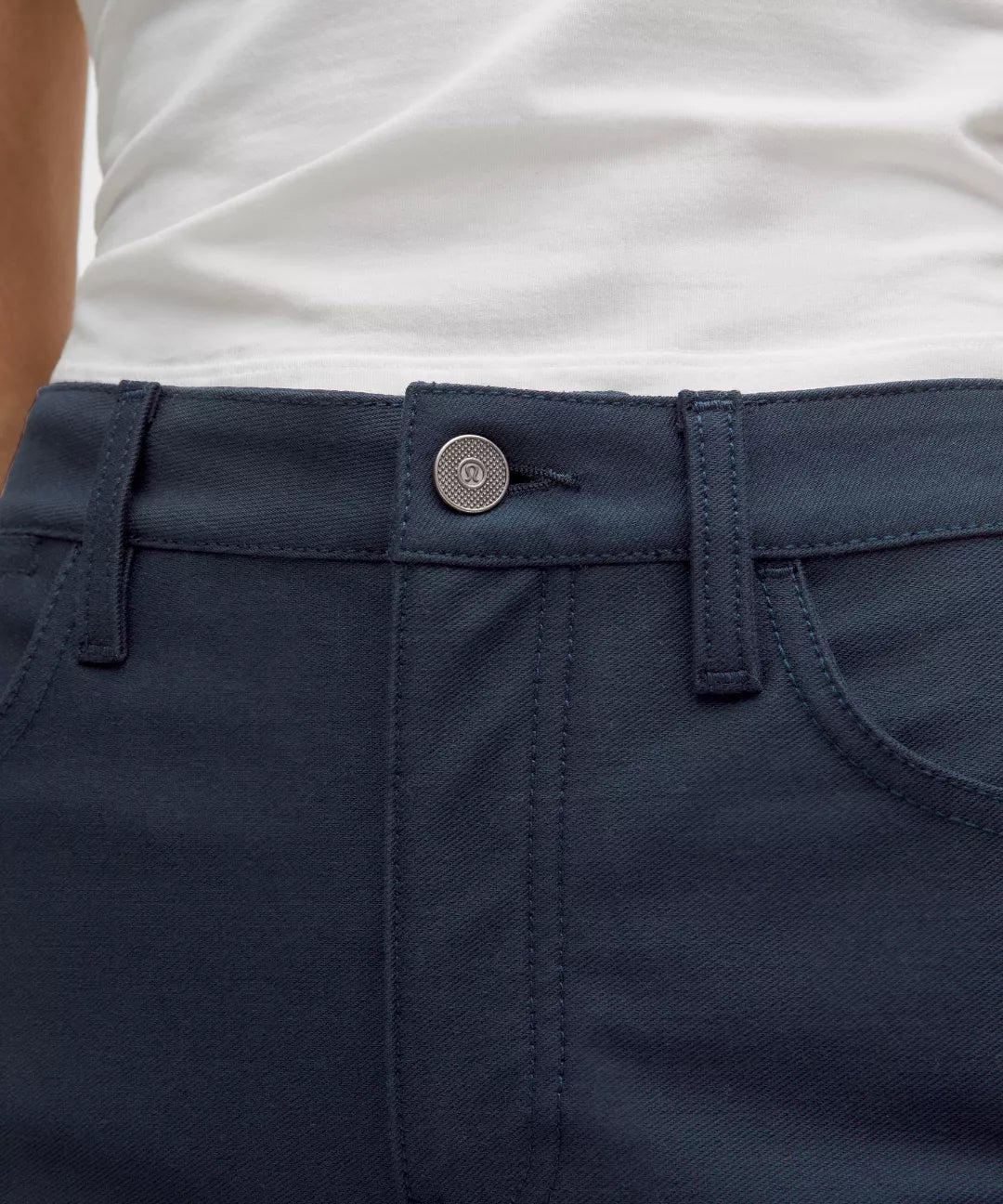Close-up of navy pants with a button on a white background