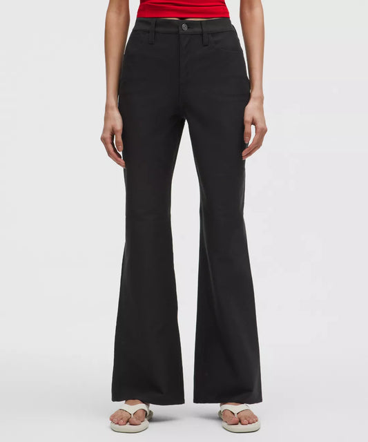 Person wearing black flared pants on a white background
