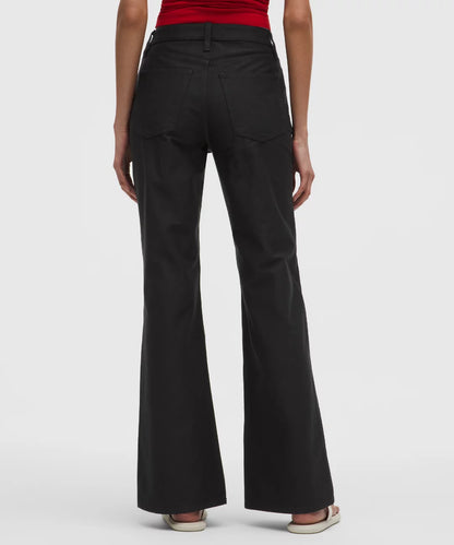 Black flared pants worn by a person on a white background