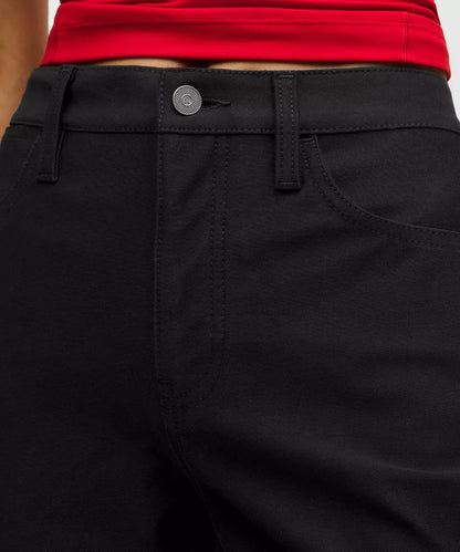 Close-up of black pants with a red top worn by a person