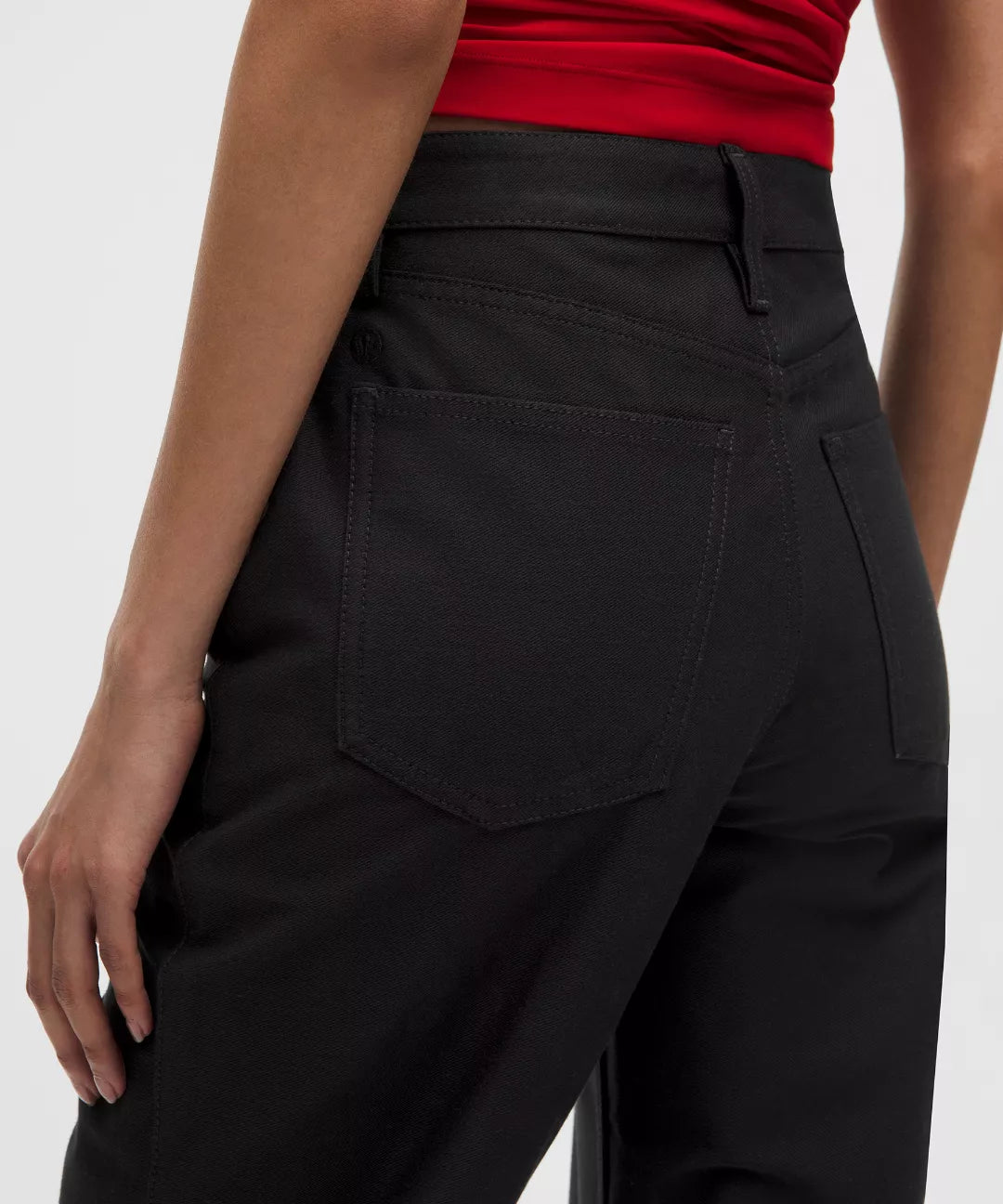 Black pants worn by a person on a white background