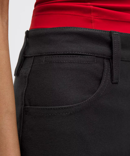 Close-up of black pants with a red shirt underneath on a white background