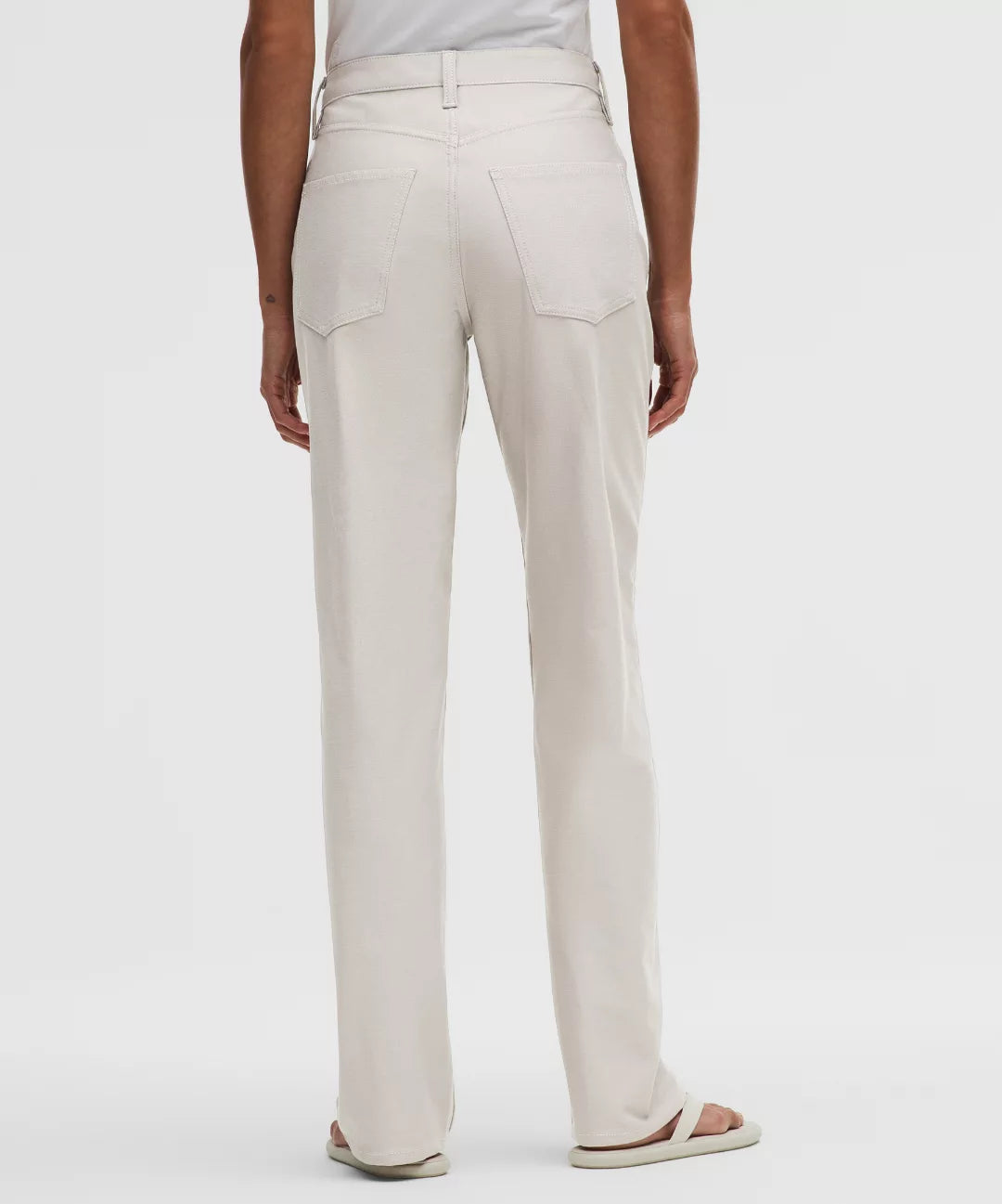 Beige pants worn by a person on a white background