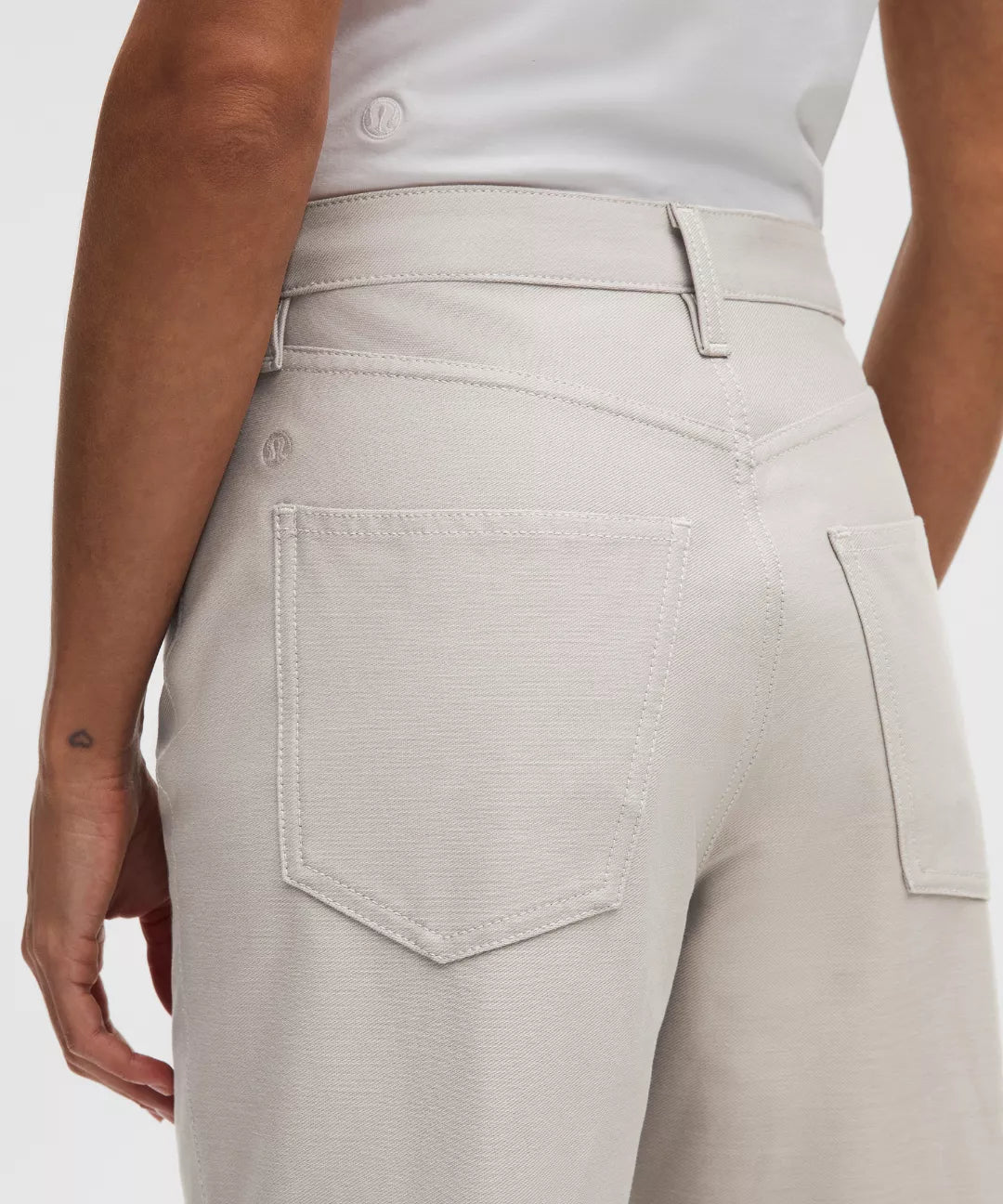 Beige pants worn by a person on a white background