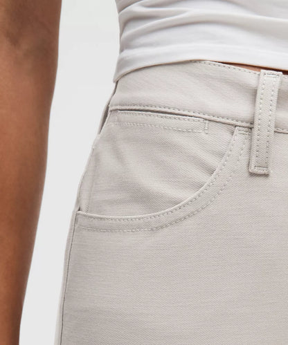 Close-up of light gray pants with a white shirt underneath