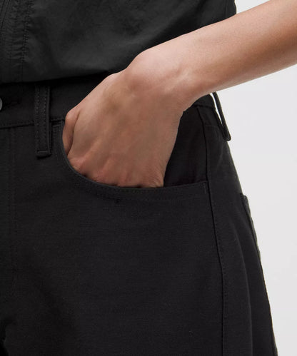 Person wearing black pants with a neutral background