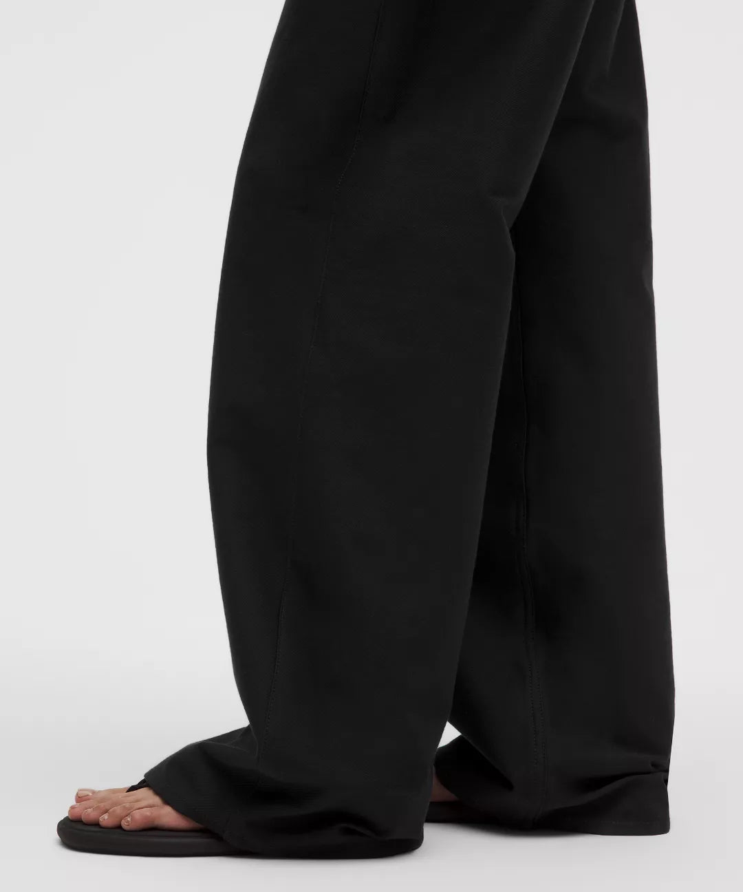 Black wide-leg pants worn by a person on a white background
