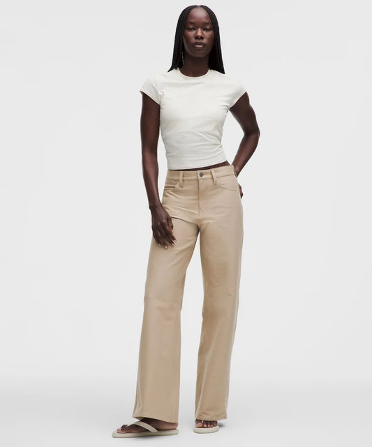 Woman wearing a white t-shirt and beige pants on a white background