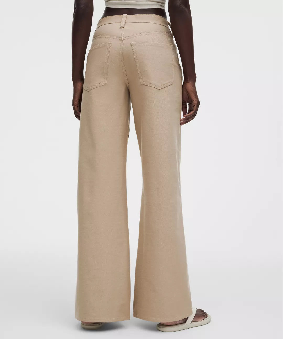 Beige wide-leg pants worn by a person on a white background