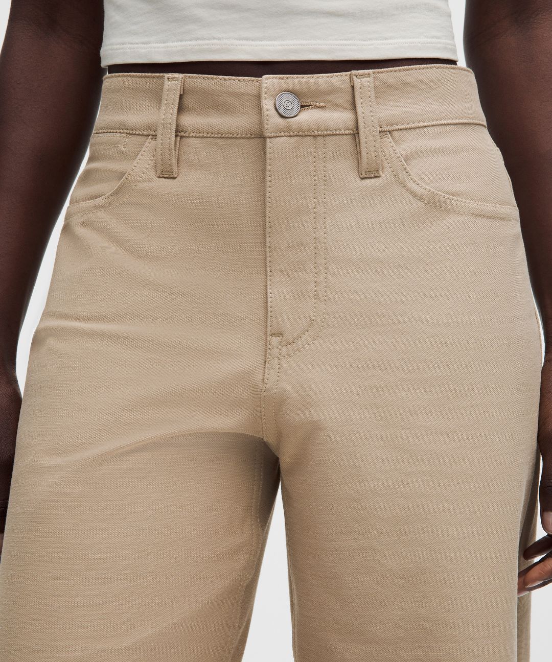 Beige pants worn by a person on a white background