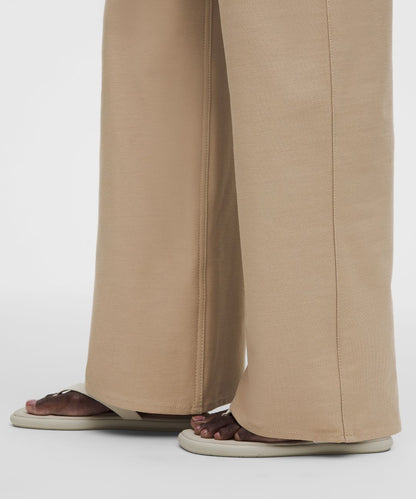 Beige pants worn by a person on a white background