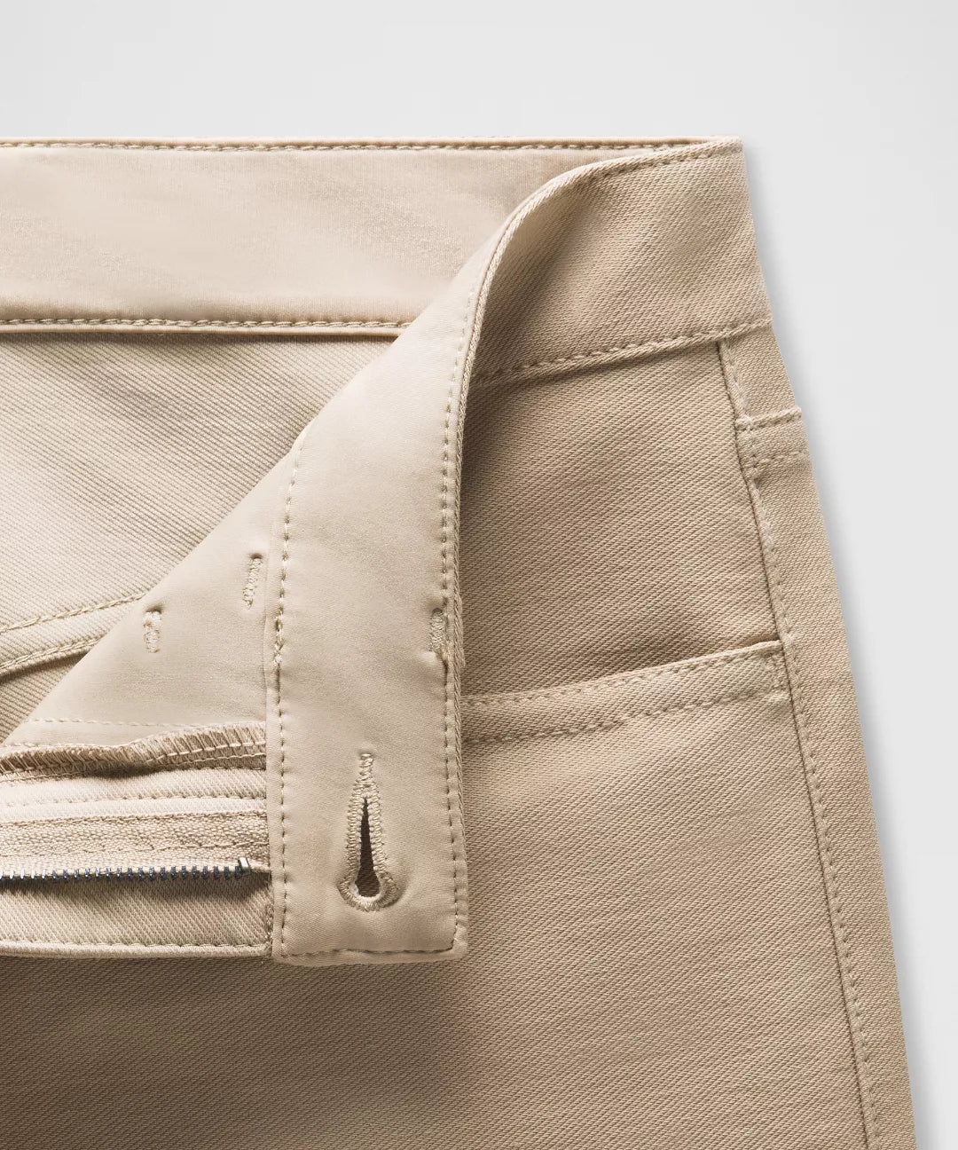 Close-up of beige pants with a white background