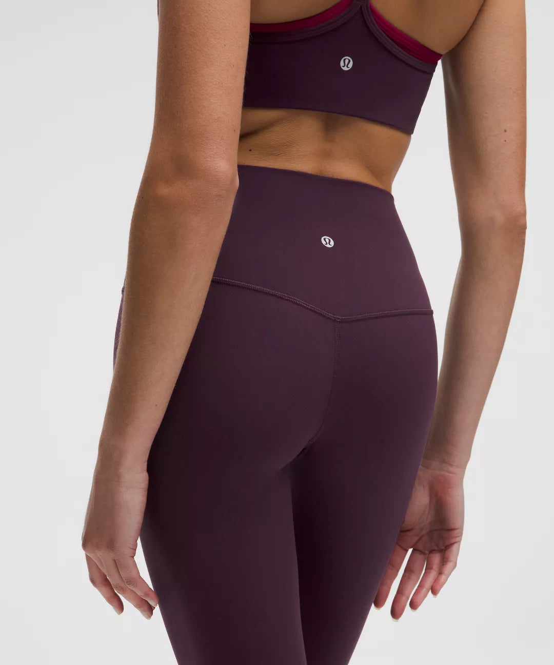 Maroon athletic leggings with a brand logo on a white background