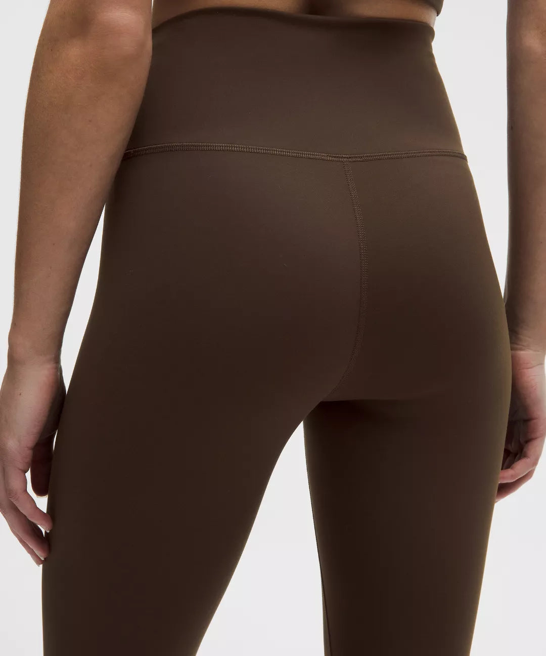 Brown leggings worn by a person on a white background