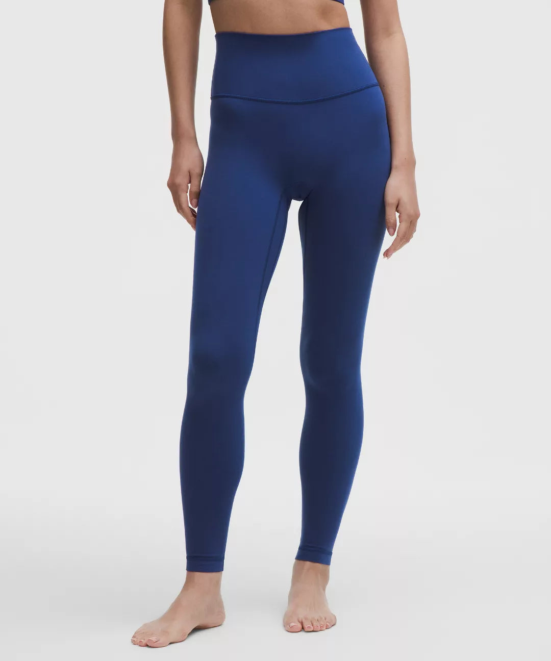 Person wearing blue leggings on a white background